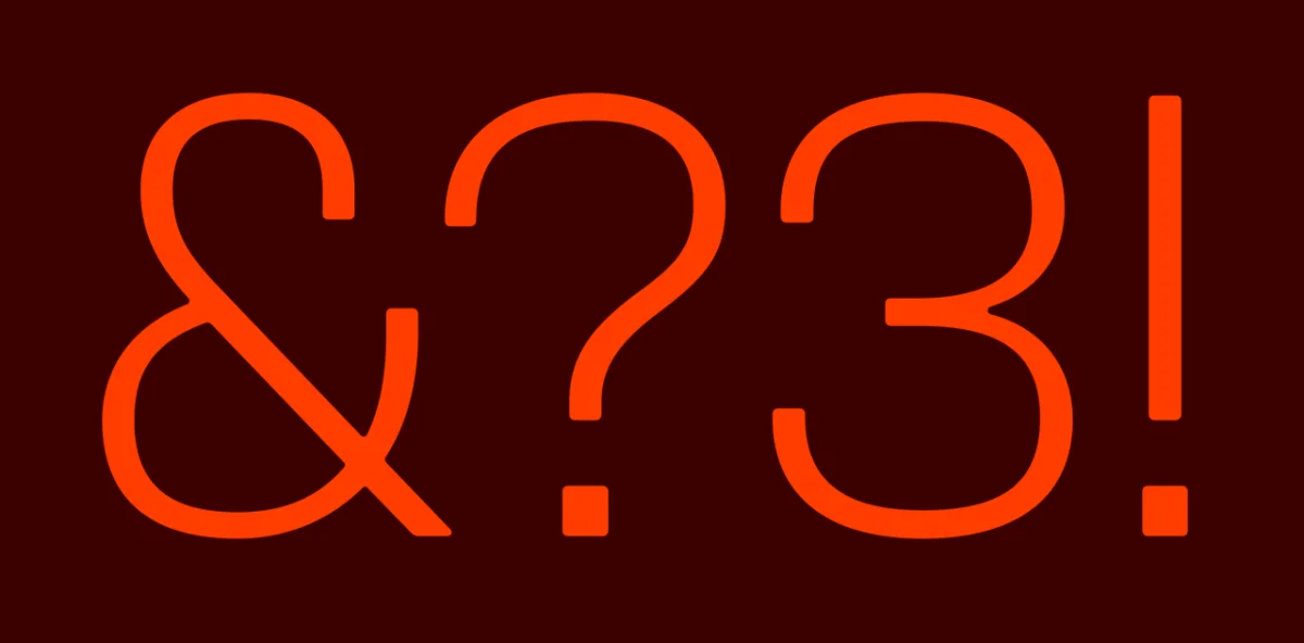 Bright orange ampersand, question mark and exclamation mark characters on a dark red background