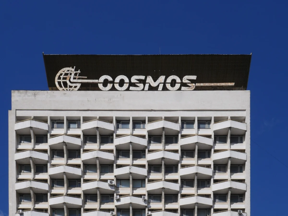 Hotel Cosmos in Moldova, a brutalist concrete tower with geometric window pattern and retro signage against a clear blue sky