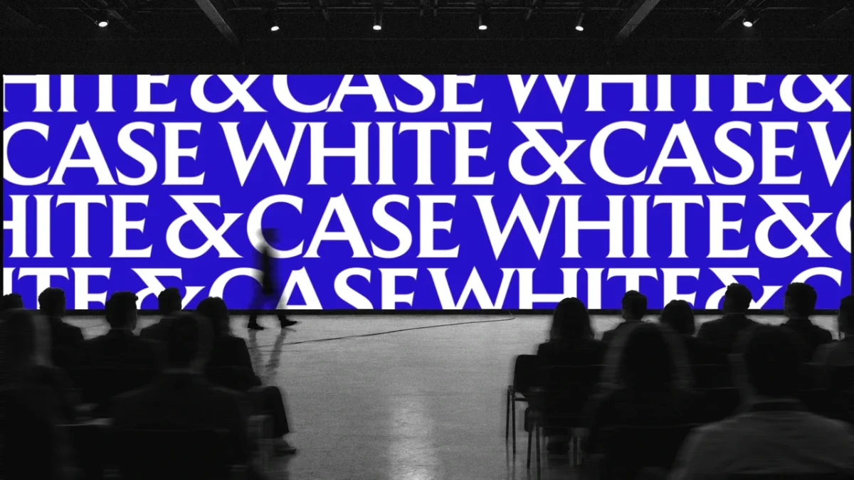 Silhouetted figures walk beneath a large blue screen displaying repeating "White & Case" text in white capital letters inside a dark venue