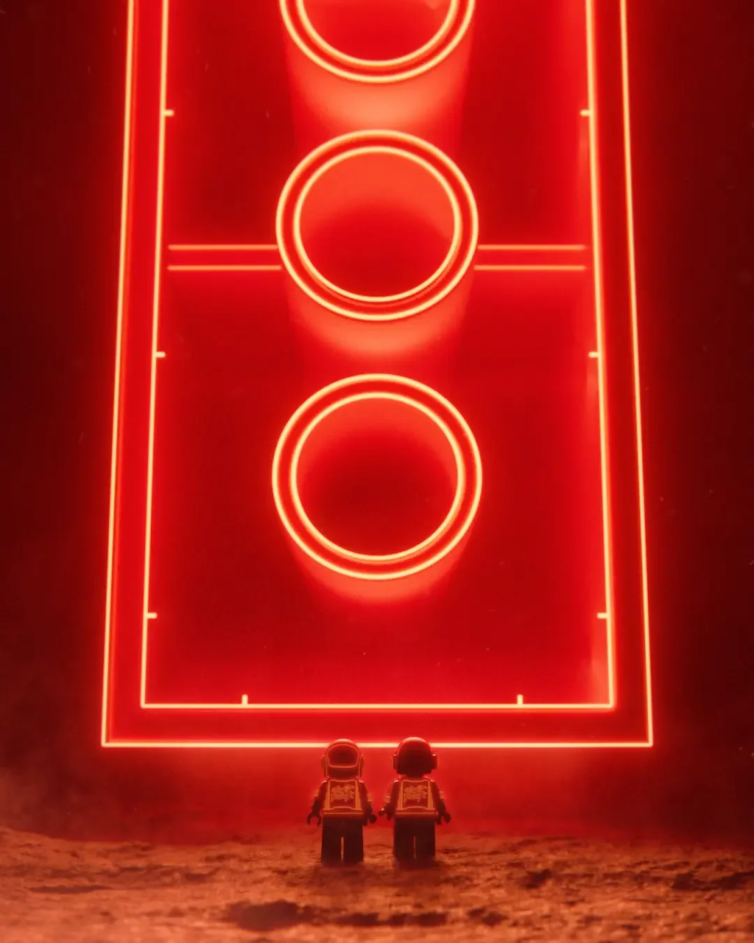 Two Lego astronauts stand on a red-dust landscape facing a massive glowing neon sign shaped like a football pitch with three illuminated circles