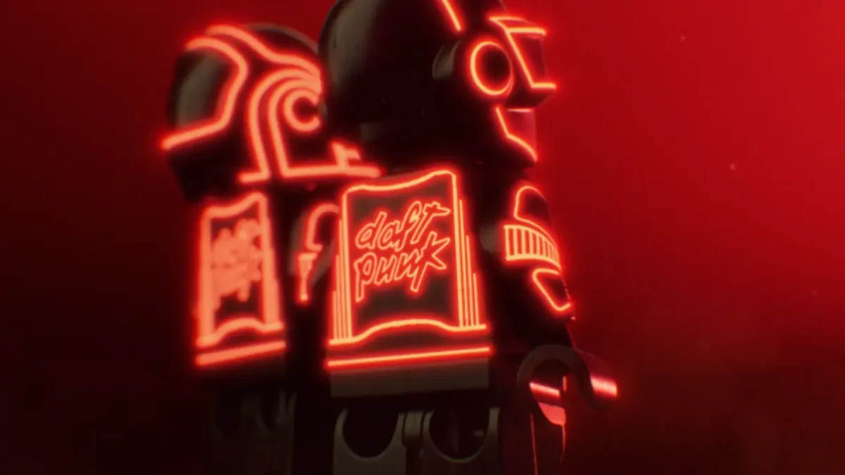 Red neon sign displaying stylised text and geometric shapes against a dark background