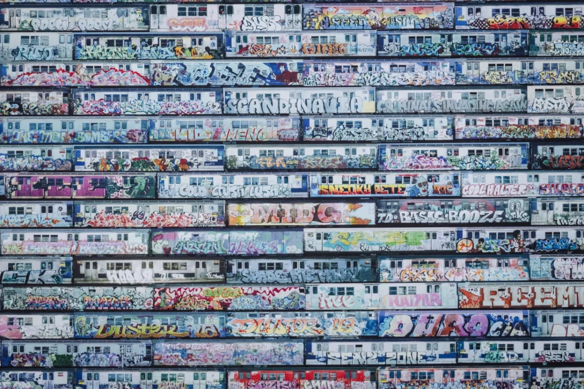 Stacked rows of horizontal building facades densely covered in colourful graffiti tags and street art designs