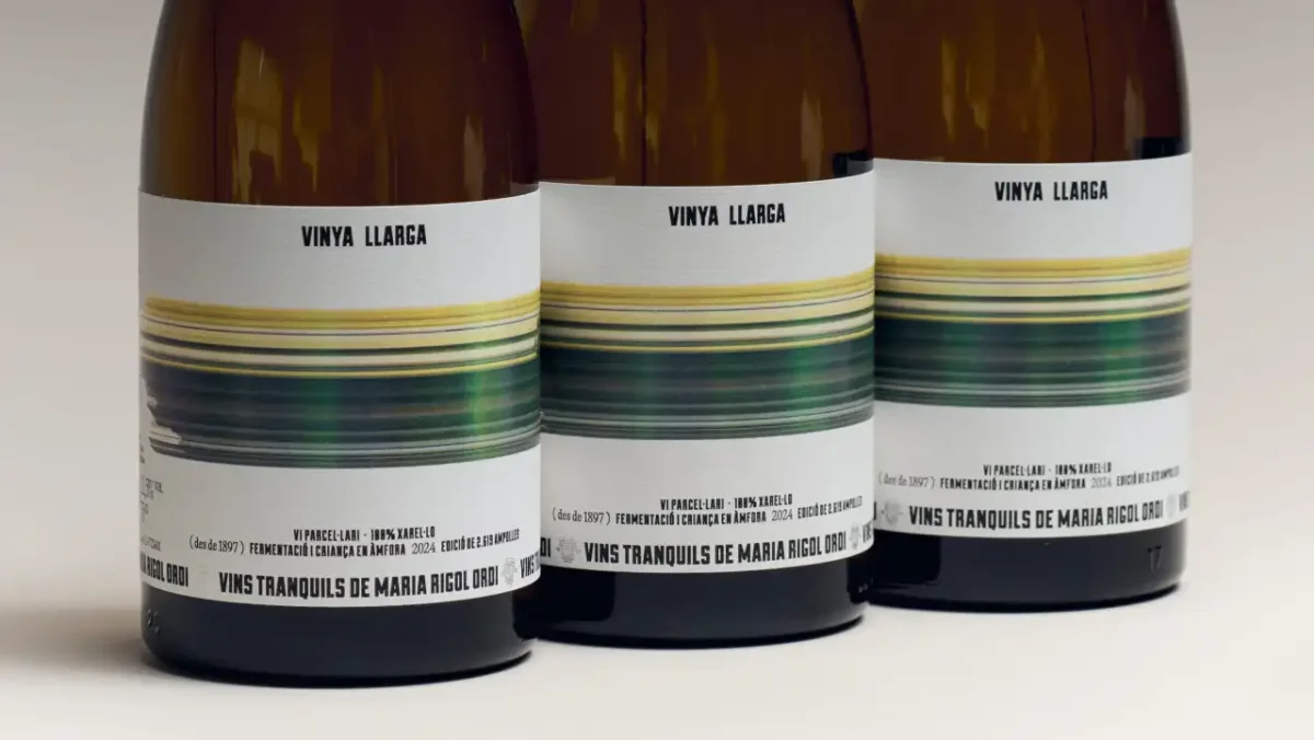 Three brown glass bottles of Vinya Llarga wine with white labels featuring horizontal streaks of yellow, green and blue that create a motion-blur effect around the bottle